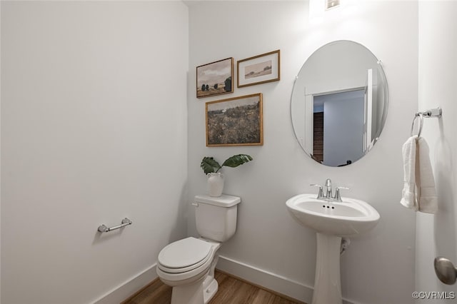 bathroom featuring hardwood / wood-style flooring, toilet, and sink