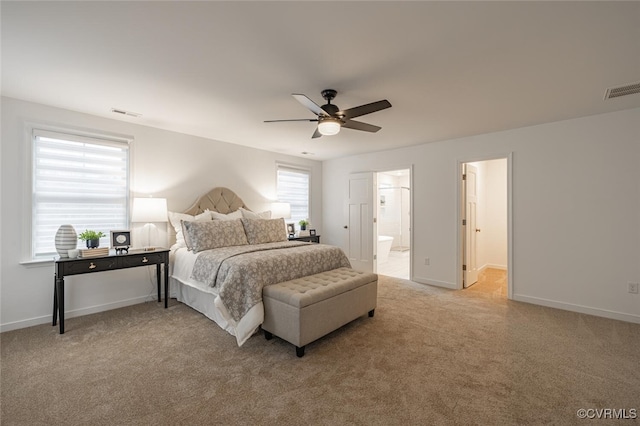 bedroom with connected bathroom, light carpet, and ceiling fan