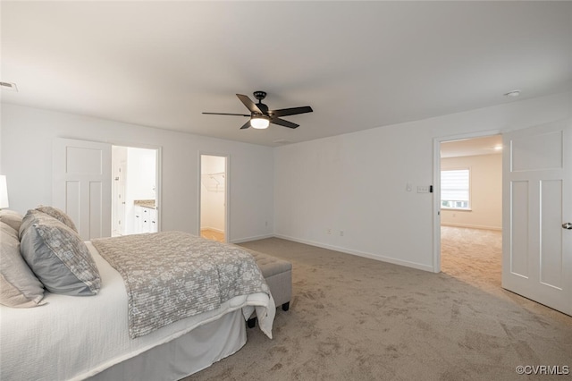 bedroom featuring ensuite bathroom, light carpet, and ceiling fan