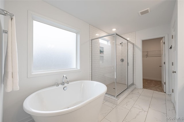 bathroom featuring shower with separate bathtub