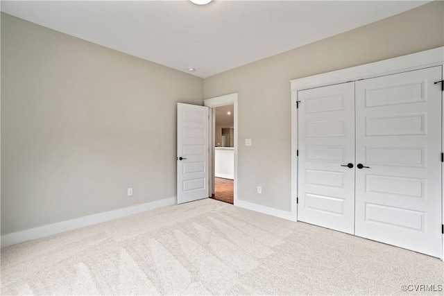 unfurnished bedroom featuring light carpet and a closet