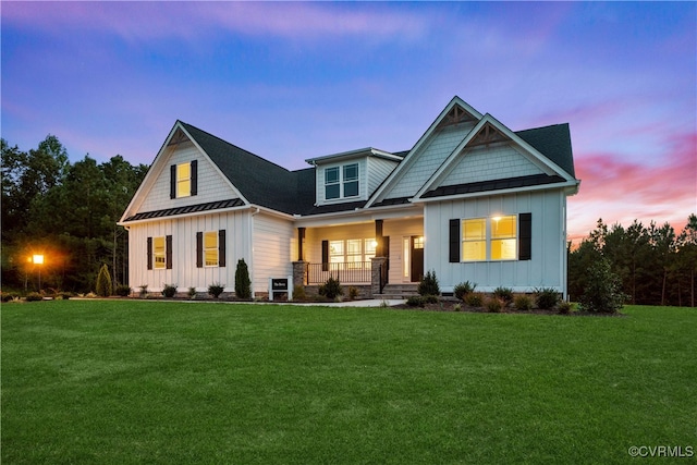 view of front of house featuring covered porch and a lawn