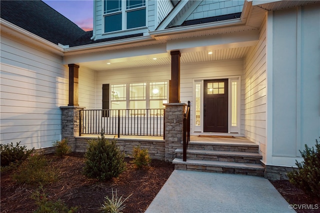 exterior entry at dusk featuring covered porch