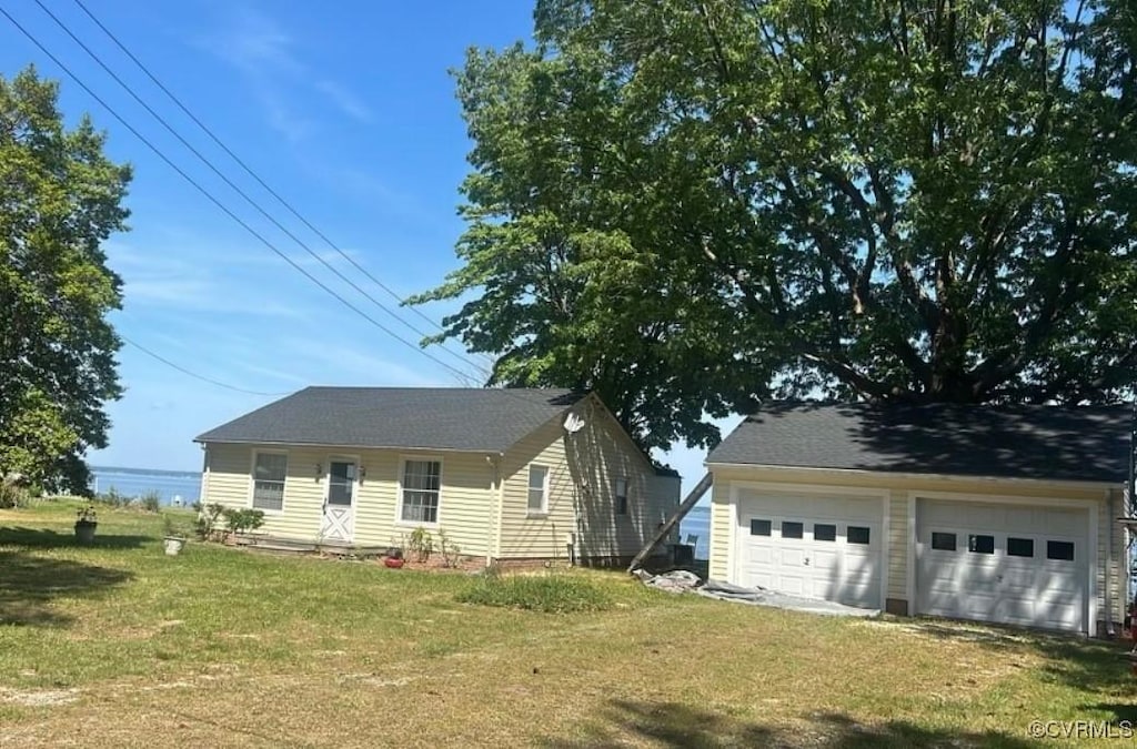 view of front facade with a garage, an outdoor structure, and a front lawn