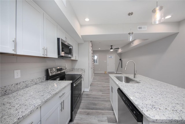 2414 Marion Mashore St, Richmond, VA 23224 - kitchen with white cabinetry, hanging light fixtures, light stone countertops, and appliances with stainless steel finishes