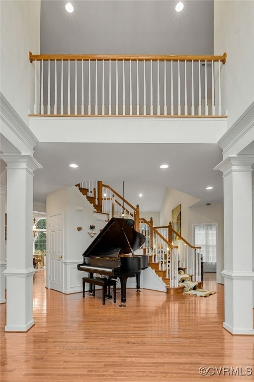 miscellaneous room featuring decorative columns and a high ceiling