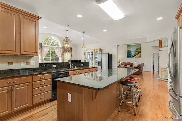 kitchen featuring stainless steel fridge with ice dispenser, stainless steel refrigerator, a kitchen breakfast bar, black dishwasher, and a kitchen island