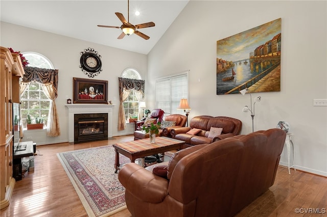 living room with high vaulted ceiling, light hardwood / wood-style floors, and a wealth of natural light