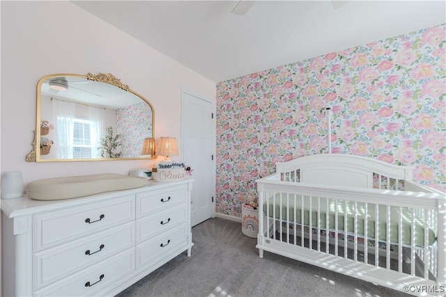 carpeted bedroom featuring a nursery area