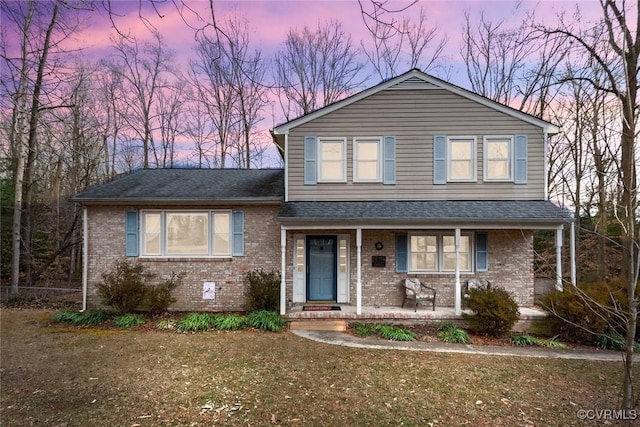 view of front facade with a yard and covered porch