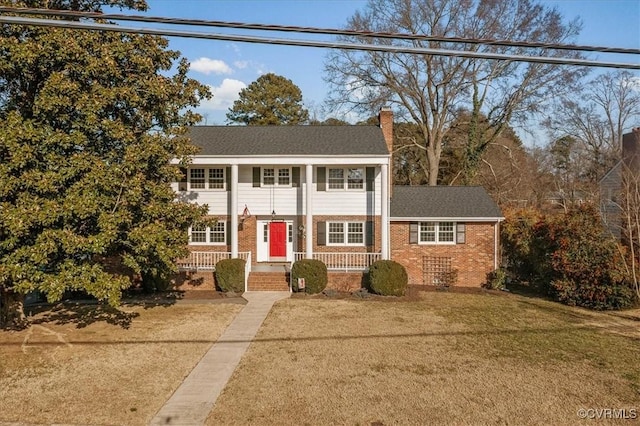 view of front of house with covered porch and a front lawn