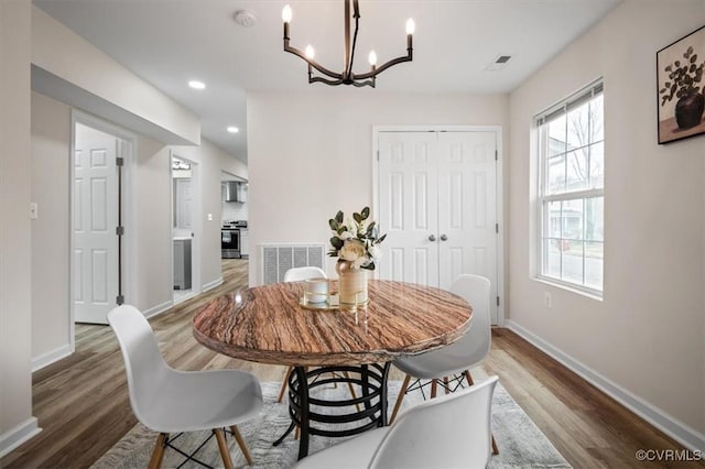 dining room featuring dark hardwood / wood-style flooring and an inviting chandelier