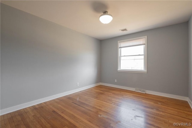 spare room with wood-type flooring