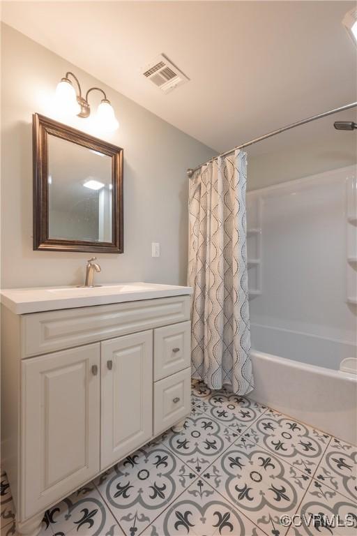 bathroom with shower / tub combo with curtain, vanity, and tile patterned floors