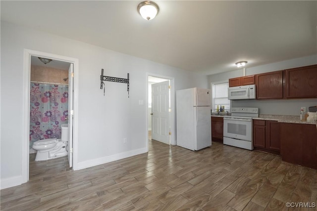 kitchen with hardwood / wood-style flooring and white appliances