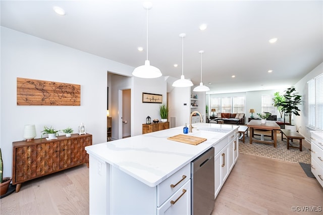 kitchen with pendant lighting, white cabinetry, dishwasher, and an island with sink