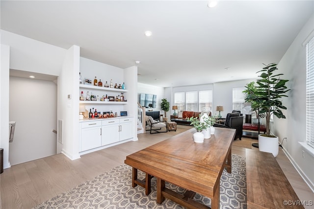 dining room featuring bar area and light wood-type flooring