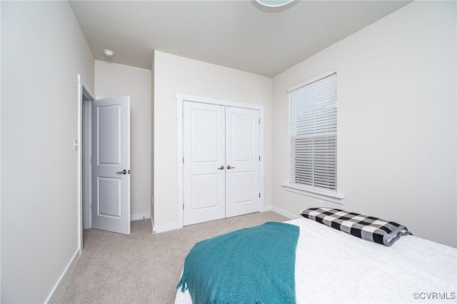 bedroom with light carpet and a closet