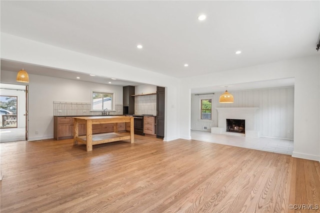 unfurnished living room with sink and light wood-type flooring