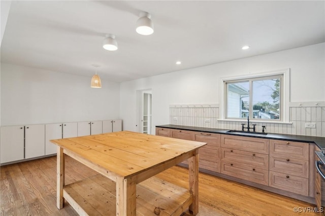 kitchen featuring sink, white cabinetry, decorative light fixtures, light brown cabinets, and light hardwood / wood-style floors