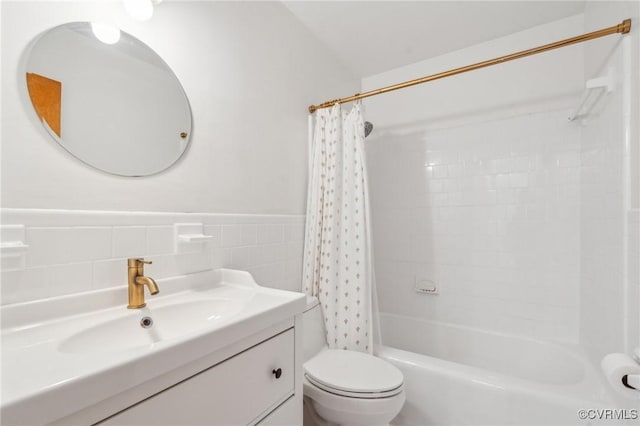 full bathroom with vanity, toilet, shower / bath combo with shower curtain, and tile walls