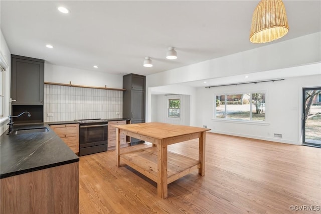 kitchen featuring plenty of natural light, light hardwood / wood-style floors, sink, and electric range oven