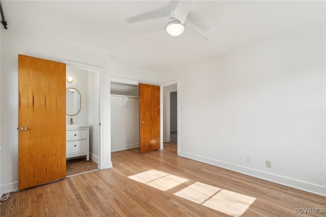 unfurnished bedroom with ensuite bath, light hardwood / wood-style floors, a closet, and ceiling fan