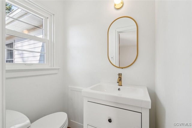 bathroom featuring vanity, toilet, and a wealth of natural light