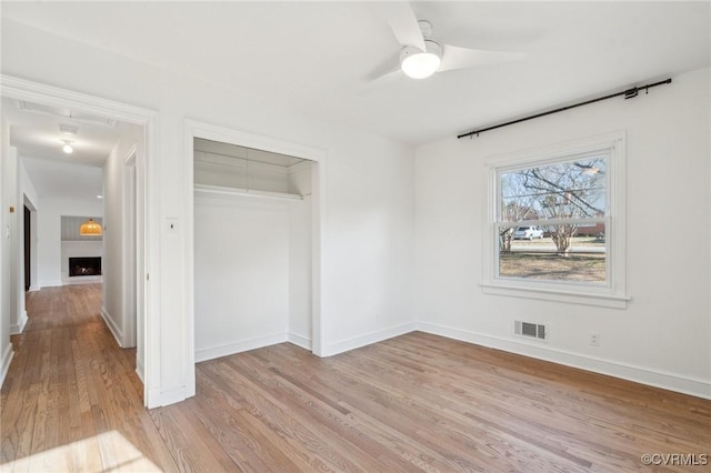 unfurnished bedroom with a closet, ceiling fan, and light hardwood / wood-style flooring