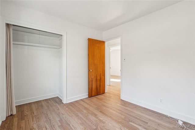 unfurnished bedroom with a closet and light wood-type flooring