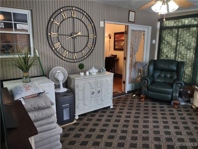 living area with ceiling fan and dark colored carpet