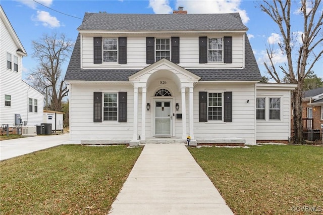 view of front of house featuring central AC unit and a front yard