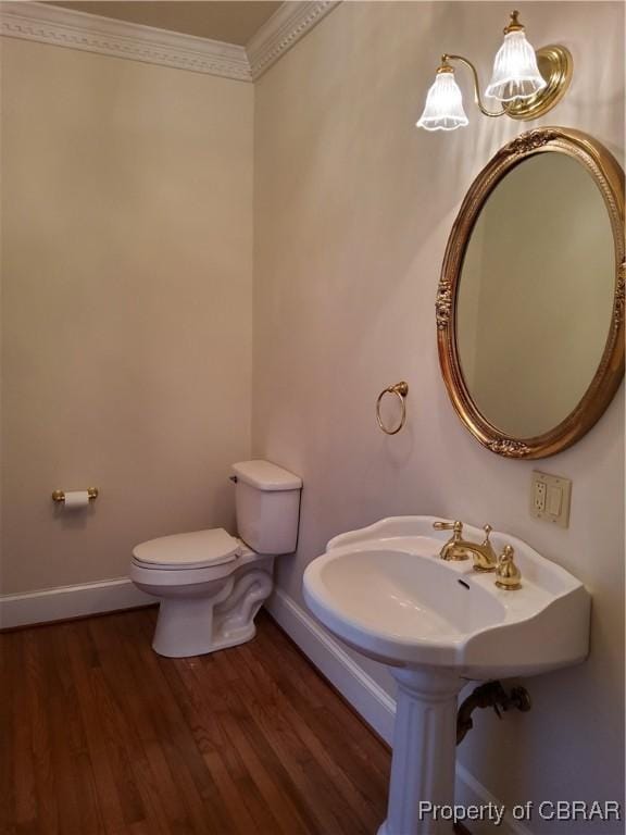 bathroom with hardwood / wood-style floors, sink, a chandelier, ornamental molding, and toilet