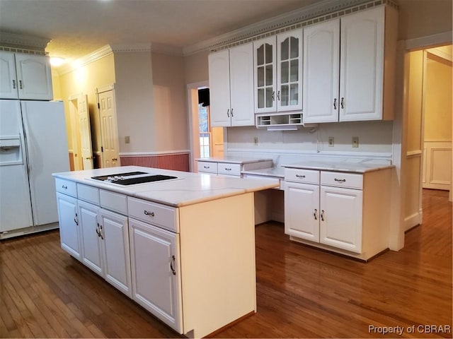 kitchen with crown molding, a center island, white fridge with ice dispenser, hardwood / wood-style flooring, and white cabinets