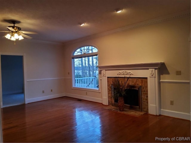 unfurnished living room featuring dark wood-type flooring, ceiling fan, and crown molding