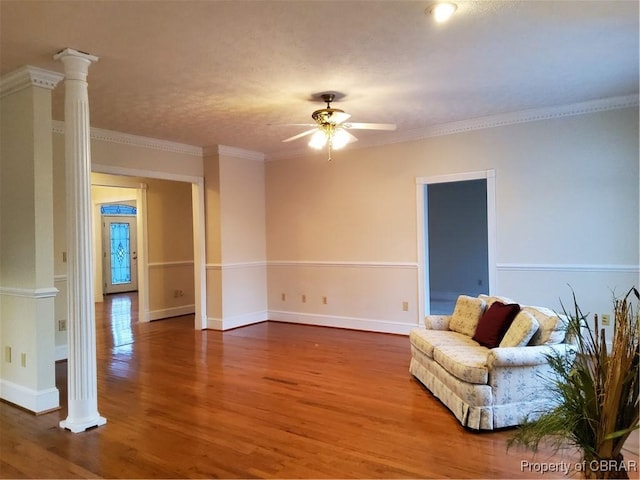 living area with hardwood / wood-style flooring, ceiling fan, ornamental molding, and decorative columns