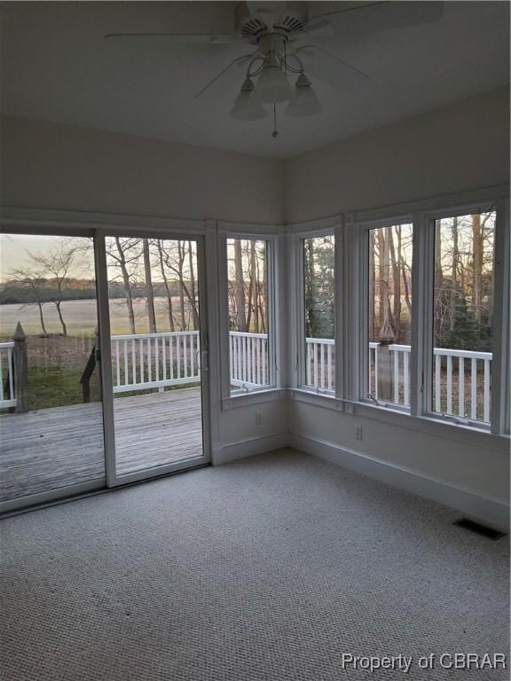 unfurnished sunroom with ceiling fan