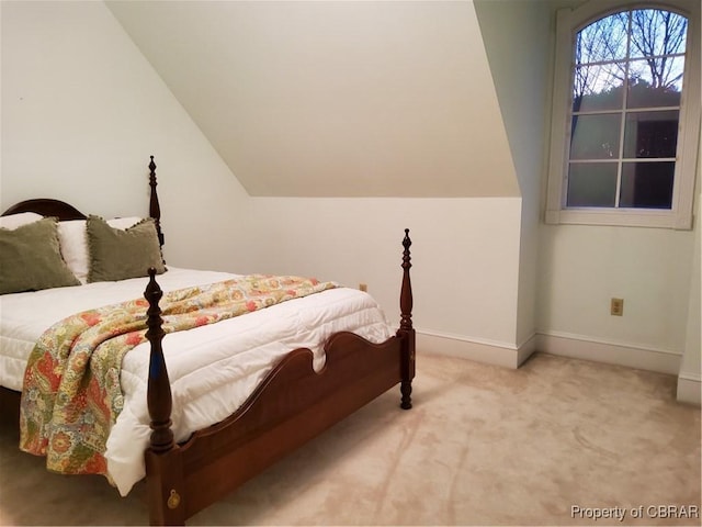 carpeted bedroom with lofted ceiling