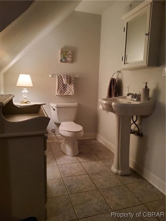 bathroom with tile patterned floors, toilet, and vaulted ceiling