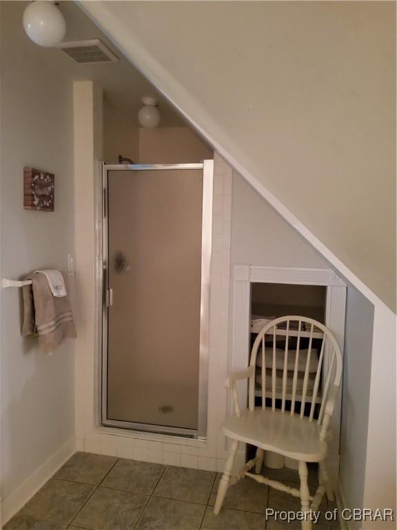 bathroom with an enclosed shower and tile patterned floors