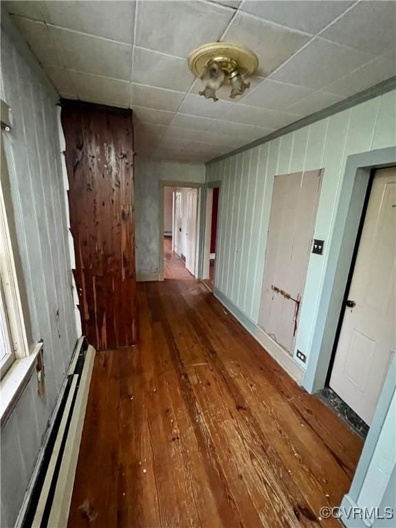 hallway with hardwood / wood-style flooring and baseboard heating