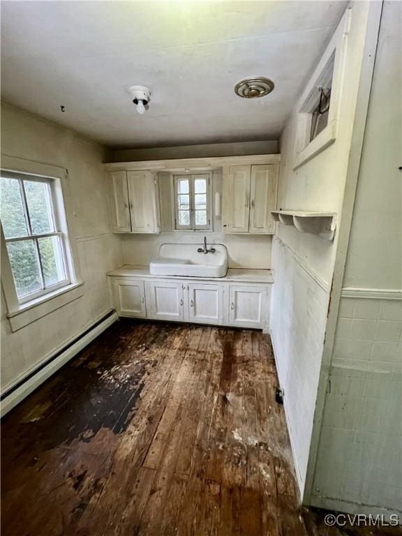 kitchen featuring a baseboard heating unit, white cabinetry, sink, and dark hardwood / wood-style floors