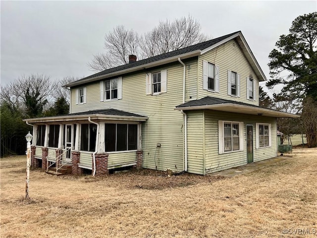 back of house with a yard and a sunroom