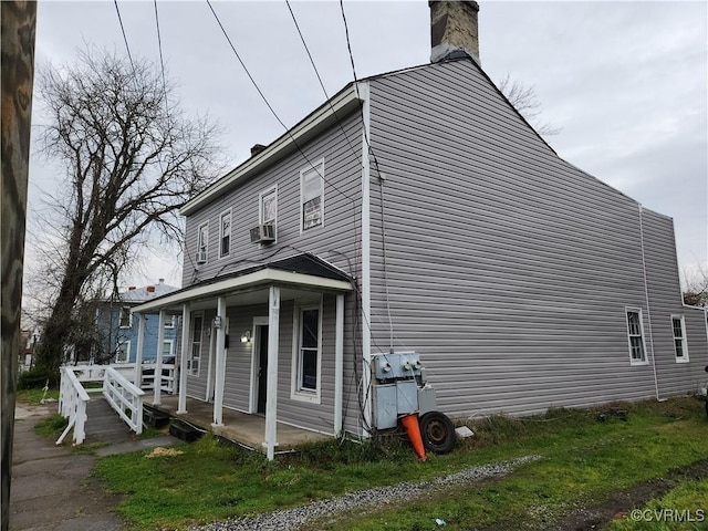 view of side of home featuring cooling unit and covered porch