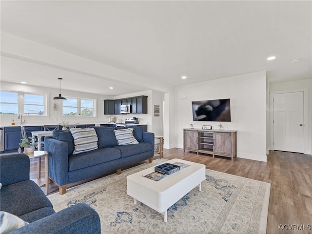 living room with sink and light wood-type flooring