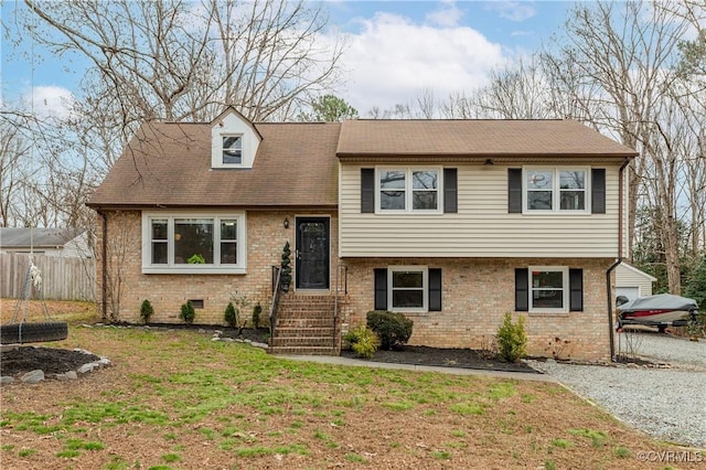 tri-level home featuring a garage and a front lawn