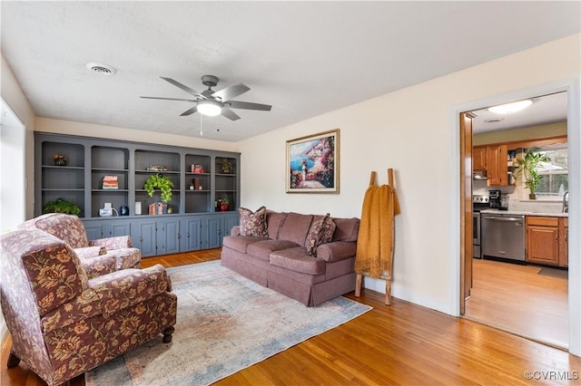 living room featuring ceiling fan and light hardwood / wood-style flooring