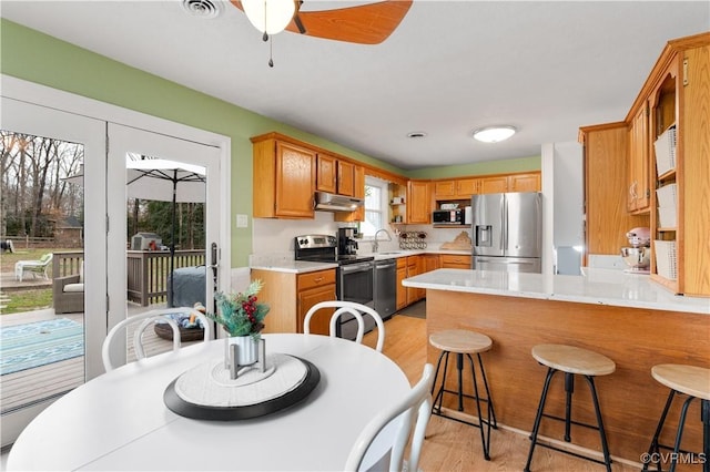 dining room with ceiling fan, light hardwood / wood-style floors, and sink