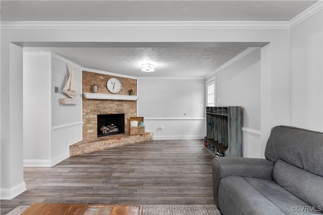 living room with crown molding, a fireplace, hardwood / wood-style floors, and a textured ceiling