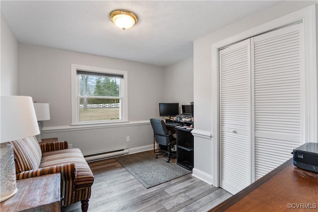 office area featuring light hardwood / wood-style flooring and a baseboard heating unit